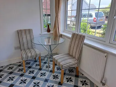 a dining room with a glass table and two chairs at AcLand Lodge Dovercourt West in Harwich