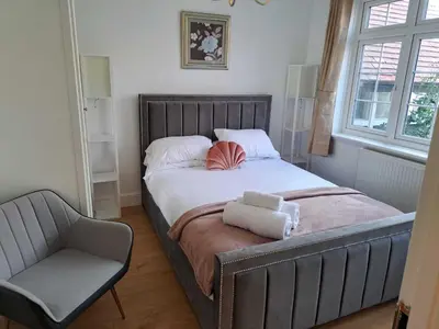 a bed with two pillows and a chair in a bedroom at AcLand Lodge Dovercourt West in Harwich