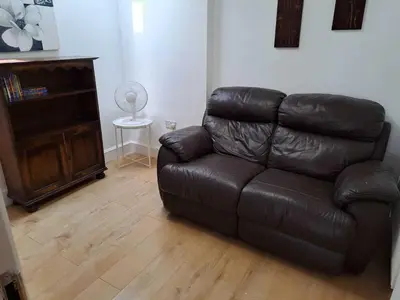a brown leather couch in a living room at AcLand Lodge Dovercourt West in Harwich