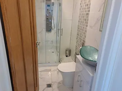 a bathroom with a shower and a toilet and a sink at AcLand Lodge Dovercourt West in Harwich