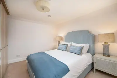a bedroom with a blue and white bed with pillows at Charming 4 Bed Cottage in Herts Countryside - Pass the Keys in Sacomb