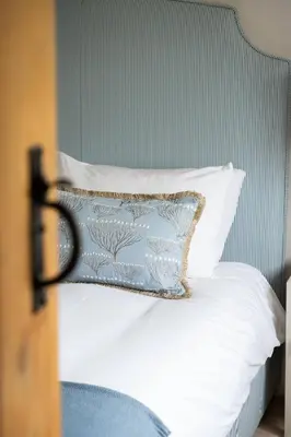 a bed with white sheets and a blue pillow at Charming 4 Bed Cottage in Herts Countryside - Pass the Keys in Sacomb