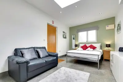a living room with a couch and a window at Pass the Keys Central Modern Cabin on Mill Road in Cambridge