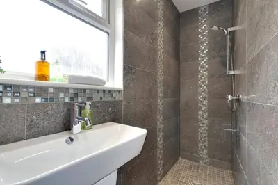 a bathroom with a sink and a shower at Pass the Keys Central Modern Cabin on Mill Road in Cambridge