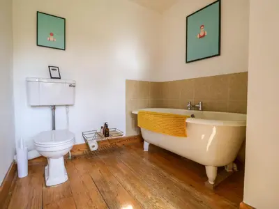 a bathroom with a tub and a toilet at Brook Farm in Harleston
