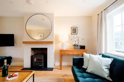 a living room with a blue couch and a mirror at 9 The Haven in Thorpeness