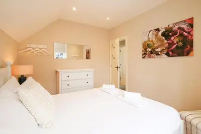 a bedroom with a white bed and a couch at 9 The Haven in Thorpeness