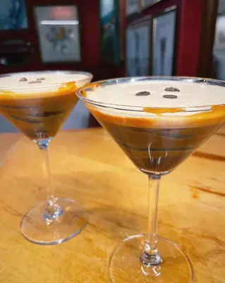 two martinis sitting on top of a wooden table at Noble Goose Rooms in Coggeshall
