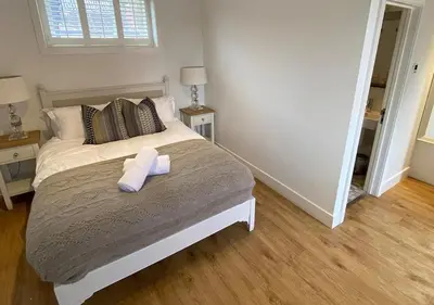 a bedroom with a bed with a towel on it at Great Blunts Stables - Stock Brook Manor Golf Club in Billericay