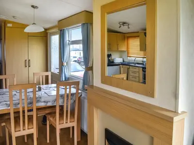 a kitchen and dining room with a table and a mirror at Swift Johnson in Dovercourt