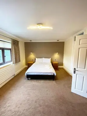 a bedroom with a bed and a window and a door at Emerson Park Mansion in Harold Wood