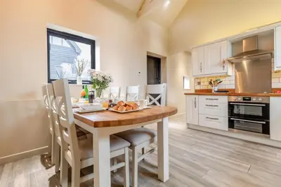 a kitchen with a wooden table and chairs in a room at 3 Bed in Heveningham oc-w29030 in Heveningham