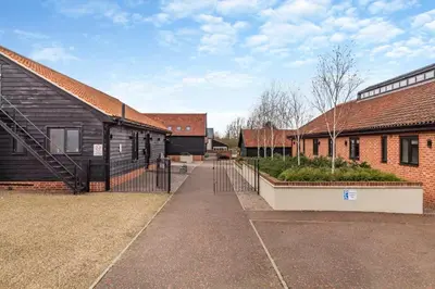 a group of buildings with a gate in the middle at 1 Bed in Heveningham oc-w29032 in Heveningham