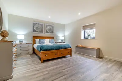 a bedroom with a bed and a dresser and two windows at 1 Bed in Heveningham oc-w29032 in Heveningham