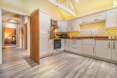 a kitchen with white cabinets and a wooden floor at 2 Bed in Heveningham oc-w29029 in Heveningham