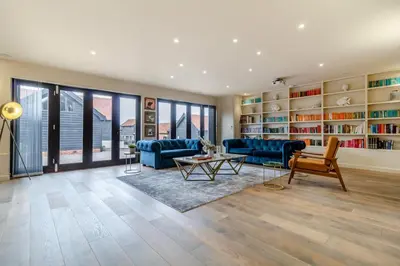 a living room with blue furniture and bookshelves at 2 Bed in Heveningham oc-w29029 in Heveningham