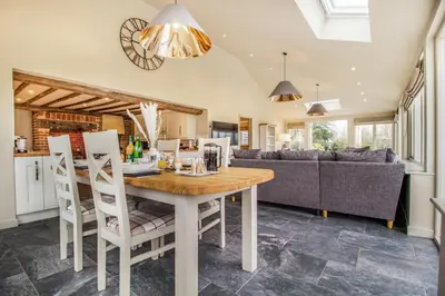 a kitchen and living room with a wooden table and chairs at 2 Bed in Heveningham oc-w29034 in Heveningham