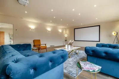 a living room with blue couches and a screen at 3 Bed in Heveningham oc-w29031 in Heveningham