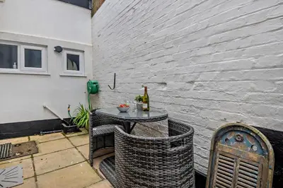 a patio with a table with two bottles of wine at 3 Bed in Aldeburgh oc-o5630 in Aldeburgh