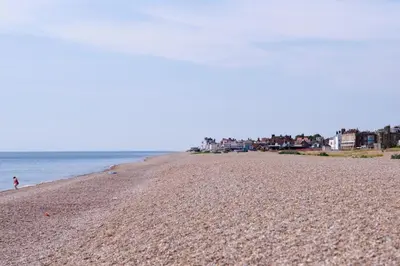 a person walking on a beach near the water at 3 Bed in Aldeburgh oc-o5630 in Aldeburgh
