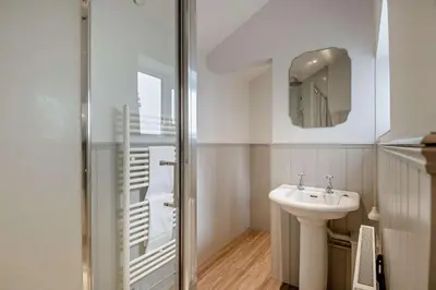 a white bathroom with a sink and a mirror at 3 Bed in Aldeburgh oc-o5630 in Aldeburgh