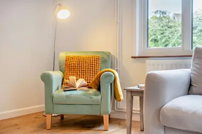 a chair with a book on it with a lamp at 3 Bed in Acton oc-c28929 in Great Waldingfield