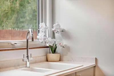 a kitchen sink with a vase of flowers in a window at 3 Bed in Acton oc-c28929 in Great Waldingfield