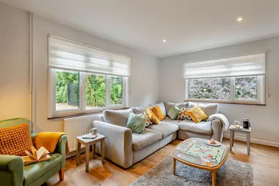 a living room with a couch and two windows at 3 Bed in Acton oc-c28929 in Great Waldingfield