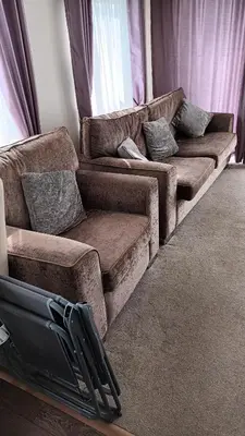 a couch sitting in a living room with curtains at 3 Bedroom caravan St osyth beach holiday park with free WiFi and parking in Great Clacton