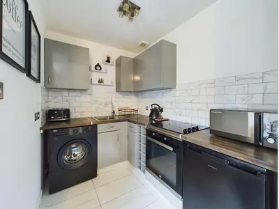 a kitchen with a washing machine and a washer at Cosy Modern Apartment Colchester in Colchester