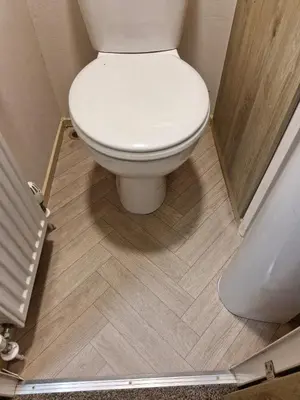 a bathroom with a white toilet and a shower at Highfield Grange Holiday Park in Little Clacton