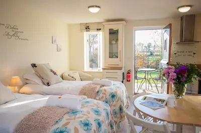 a living room with two beds and a table at Mollett's Farm in Saxmundham
