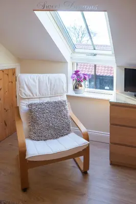 a white chair in a room with a window at Mollett's Farm in Saxmundham