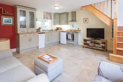 a large kitchen with a couch and a tv at Mollett's Farm in Saxmundham