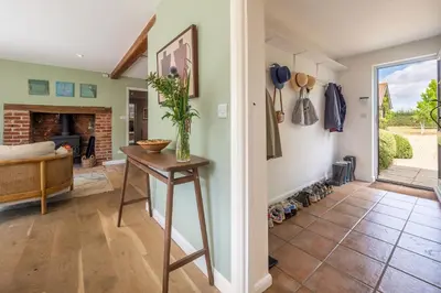 a living room with a table and a fireplace at Foxhole Cottage 8 in Stowmarket