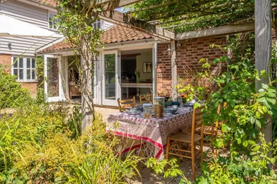 a table and chairs in the back yard of a house at Foxhole Cottage 8 in Stowmarket