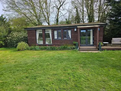 a small house with a bench in a yard at Dunmow 1-Bed Cabin Sleeps 4 10 mins to Stansted in Great Dunmow