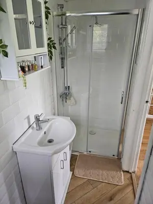 a white bathroom with a shower and a sink at Dunmow 1-Bed Cabin Sleeps 4 10 mins to Stansted in Great Dunmow