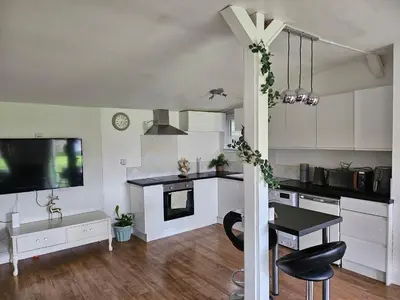 a kitchen with white cabinets and a table and a tv at Dunmow 1-Bed Cabin Sleeps 4 10 mins to Stansted in Great Dunmow