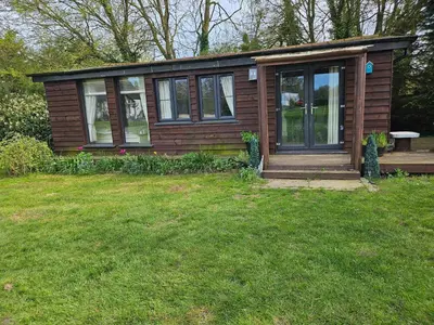 a small house with a porch and a grass yard at Dunmow 1-Bed Cabin Sleeps 4 10 mins to Stansted in Great Dunmow
