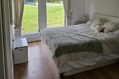 a bedroom with a bed and a large window at Dunmow 1-Bed Cabin Sleeps 4 10 mins to Stansted in Great Dunmow