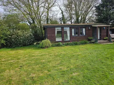 a small house in a yard with a green lawn at Dunmow 1-Bed Cabin Sleeps 4 10 mins to Stansted in Great Dunmow