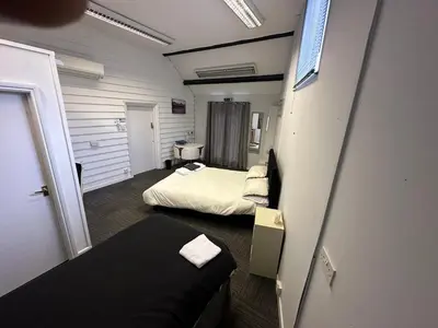 a small room with two beds and a couch at The Stables in Takeley