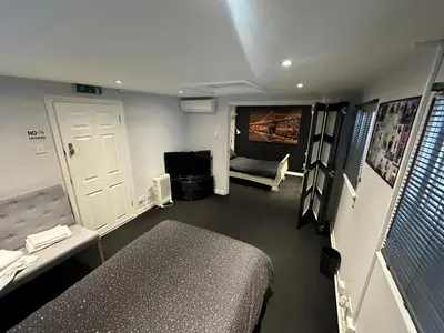 a room with a bed and a couch and a tv at The Stables in Takeley