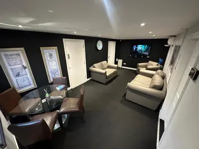 a living room with a table and chairs and a television at The Stables in Takeley