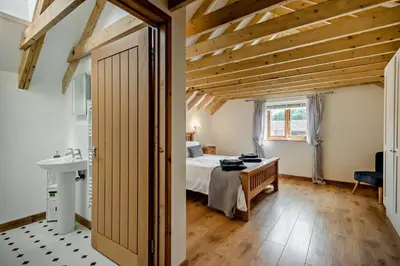 a bedroom with a bed and a desk and a sink at 4 Bed in Barnham Broom oc-b27788 in Kimberley
