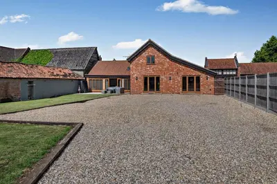 a house with a gravel driveway in front of it at 4 Bed in Barnham Broom oc-b27788 in Kimberley