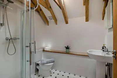 a bathroom with a shower and a toilet and a sink at 4 Bed in Barnham Broom oc-b27788 in Kimberley