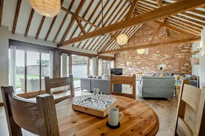 a living room with a wooden table and chairs at 4 Bed in Barnham Broom oc-b27788 in Kimberley
