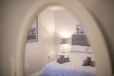 a bedroom with a bed and a table with a lamp at Beautiful Ground Floor Victorian Apartment in Clacton-on-Sea